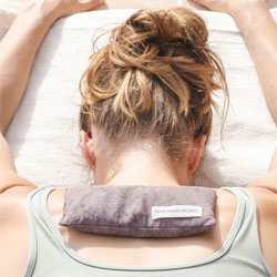 Rianne in a restorative pose with an eye pillow between her shoulderblades